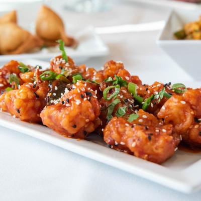 Fried coated cauliflower flowerets with honey and soy sauce, topped with sesame seeds.