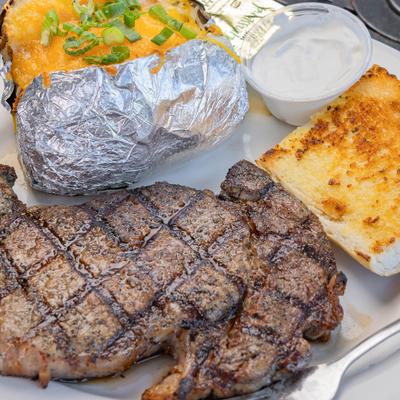Grilled ribeye served with loaded potato, cornbread and a dipping sauce.