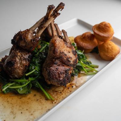 Grilled lamb chops served with sauteed greens and cornbread muffins.