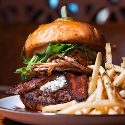 Blue Dream Burger, with bacon, gorgonzola, crispy onion rings, garlic aioli, arugula, and fries.