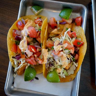 Fish tacos topped with shredded cabbage, pico de gallo and chiptole aioli