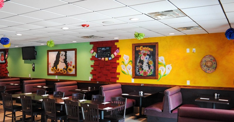 Interior, dining booths and tables, red, green and yellow wall with Mexican decorations