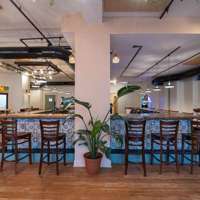 Bar area with tiled fronting and wooden bar stools, and a separate dining area.