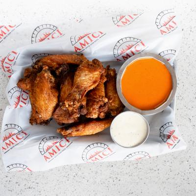 Portion of chicken wings served with two sauces, top view.