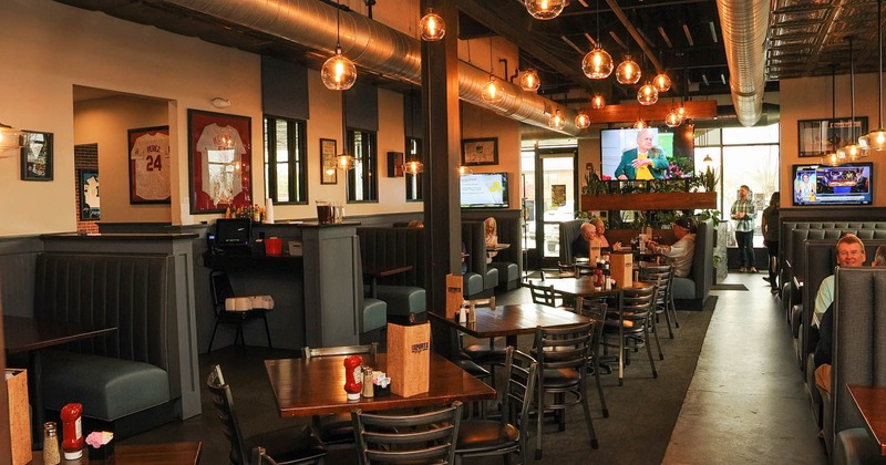Interior, people sitting in booths, lined up tables with chairs