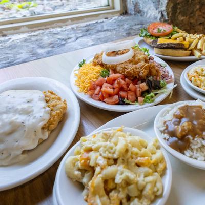 Variety of food plates spread on a wooden table.