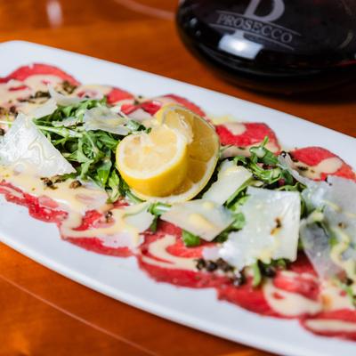 Beef carpaccio topped with cheese.