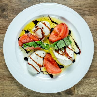 Caprese salad featuring thick slices of fresh mozzarella and tomatoes.
