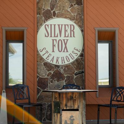 Silver Fox Steakhouse sign on a stone accent wall.