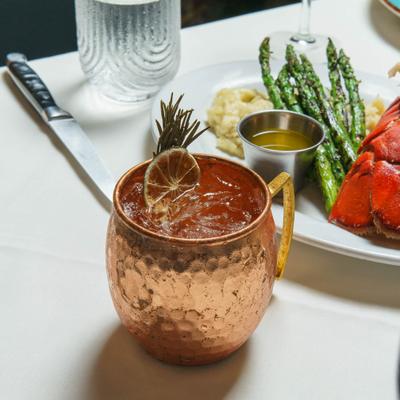 Cocktail in copper mug with dried citrus garnish.