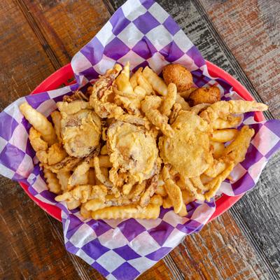 Whole fried soft-shell crabs served over a portion of french fries.