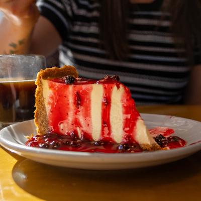 A slice of cheesecake with berry sauce.