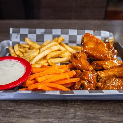 Chicken wings with fries, carrot sticks, and ranch sauce.
