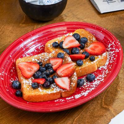 French toast topped with fresh berries and dusting of powdered sugar.