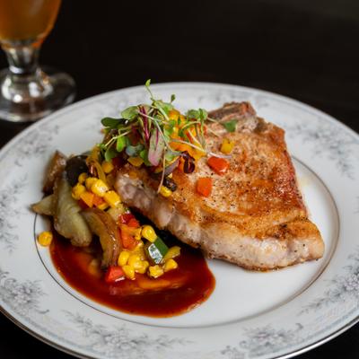Roasted pork loin served alongside corn and pepper salsa.