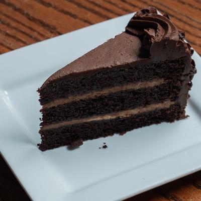 A slice of Chocolate Layer Cake served on a white plate.