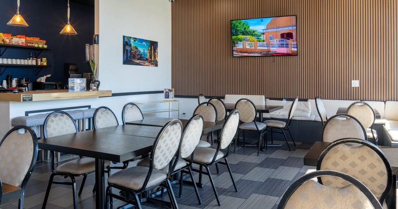 Interior, tables ready for guests, TV on the wall