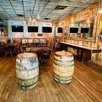 Rustic interior design with wooden barrels and tables.