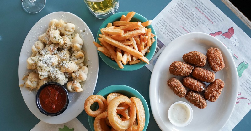 Garlic knots and jalapeno poppers served alongside fries, onion rings, and beer