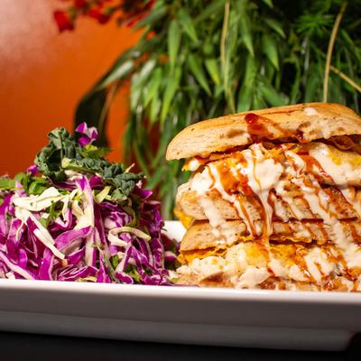 Chicken sandwich with red cabbage salad on the side.