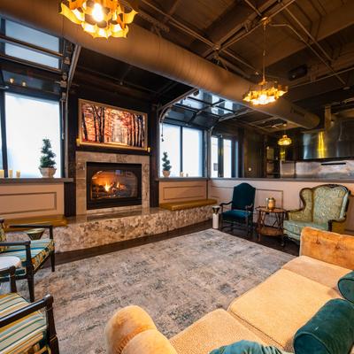 Part of a room with a fireplace, sofa, and armchairs.