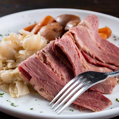 Sliced corned beef and cabbage with carrots and potatoes.