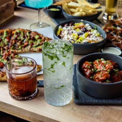 Various cocktails served on the table with assortment of dishes.