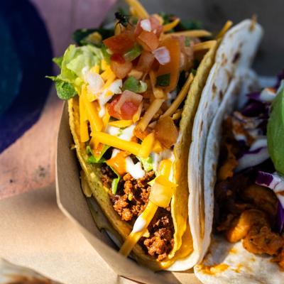 Super Fresco Taco topped with grated cheese and pico de gallo, close-up.