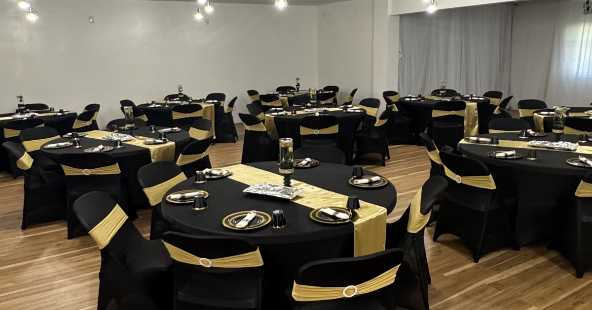 Interior, event space, round white tables, TV with sound system, wooden flooring