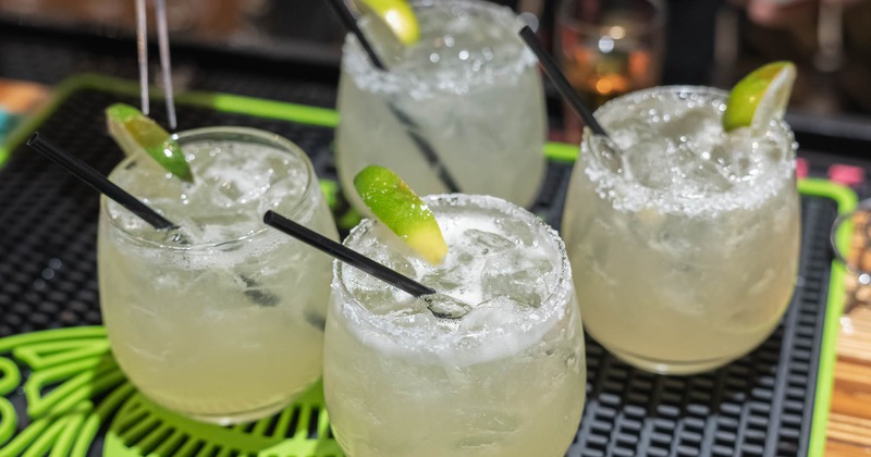 Four margarita cocktails on a bar mat