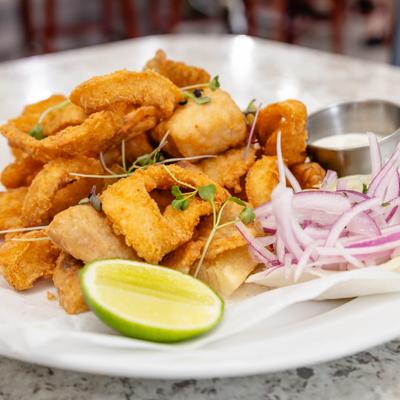 Peruvian fried seafood dish served with onions, lime, and dipping sauce.