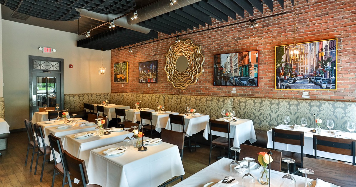 Dining room with white tablecloths and wall art