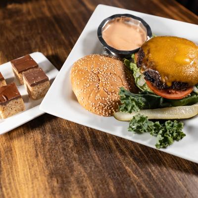 Chalice burge served on the table with plate of dessert.