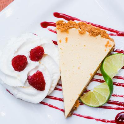 Cheesecake with whipped cream and raspberries.