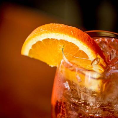 Aperol Spritz garnished with orange wedge, close up