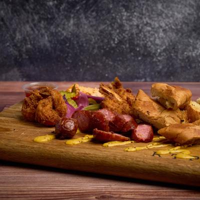 Taster board, with sausages, fried shrimp, veggies, pimento cheese, and mustard.