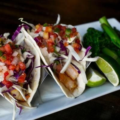 Shrimp tacos with veggies and lime on the side.