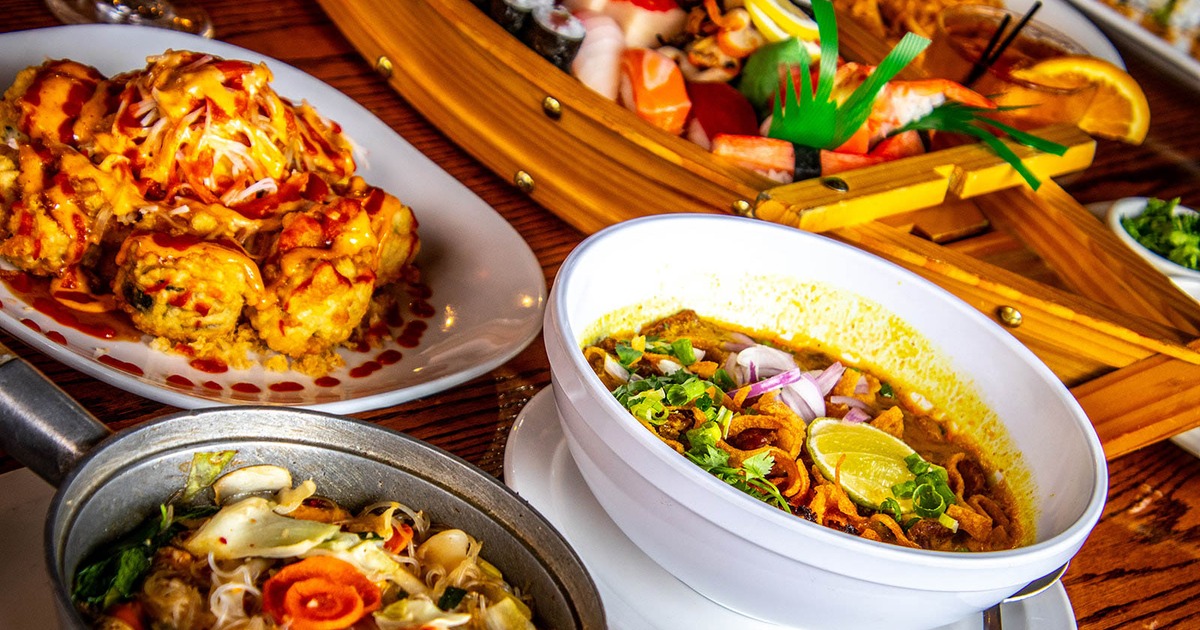 Various dishes served alongside a sushi boat platter
