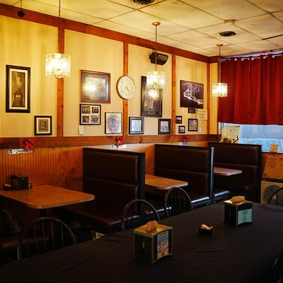 Interior featuring booths, wall art, and pendant lights.