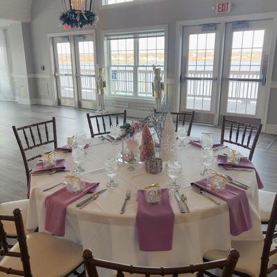 Round table dressed with pink napkins.