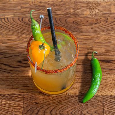 Oaxacan Spicy Margarita with tajin rim, spicy peppers as garnish.