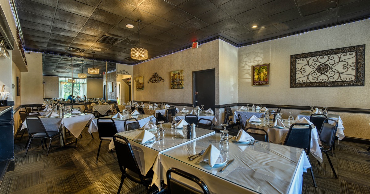 An elegant restaurant with set tables featuring white tablecloths and napkins