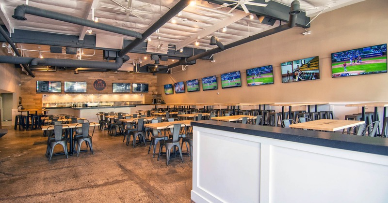 Interior, taproom, tables and seating, a row of TV screens on a wall