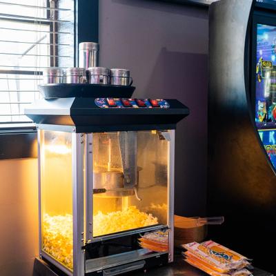 Popcorn machine with  seasoning shakers and pre-packaged popcorn kits.