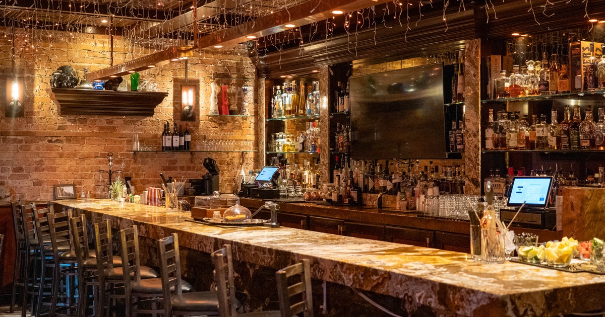 Interior featuring a rustic bar area with dark wood shelving and marble-top counter