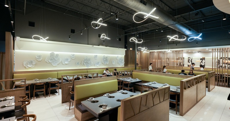 Spacious and modern interior dining area with tables equipped with built-in hot pot burners