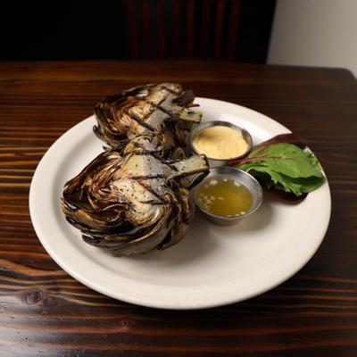 Grilled Artichoke cut in half with butter and chipotle mayo.