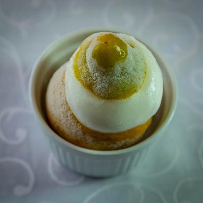 Lemon dessert served in a white ramekin, topped with ice cream.