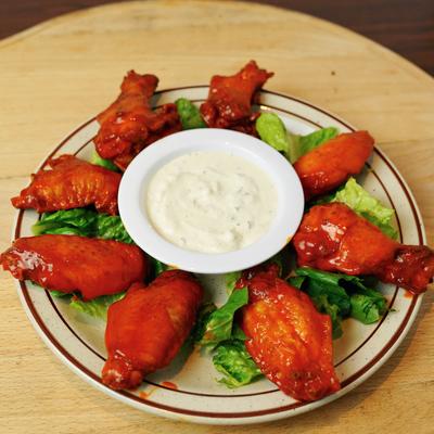 Chicken wings served with a sauce.