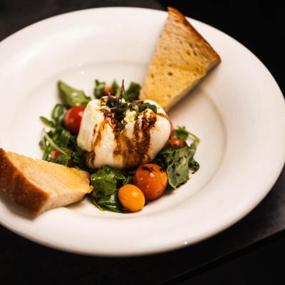 Burrata pomodoro with arugula and toasted bread.